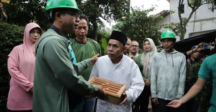 Bupati Bandung, Dadang Supriatna secara simbolis menyerahkan bantuan bedah rumah kepada warga. (Foto: Humas/Istimewa)